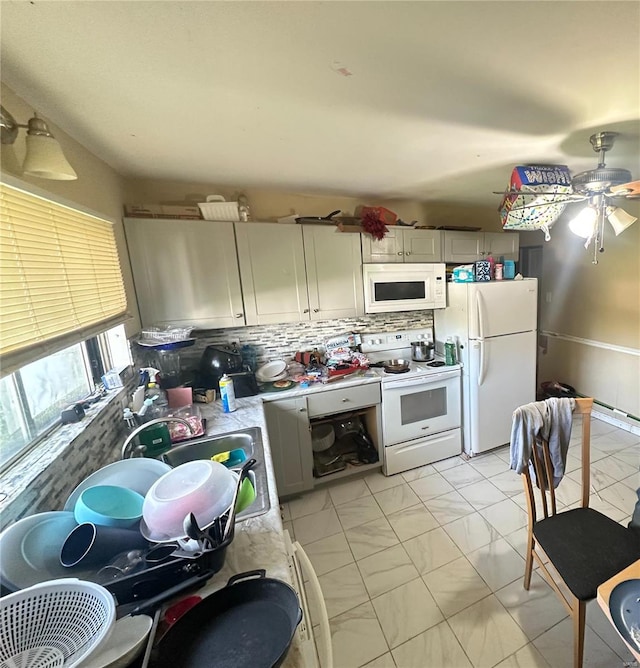 kitchen featuring tasteful backsplash, a ceiling fan, white appliances, and marble finish floor