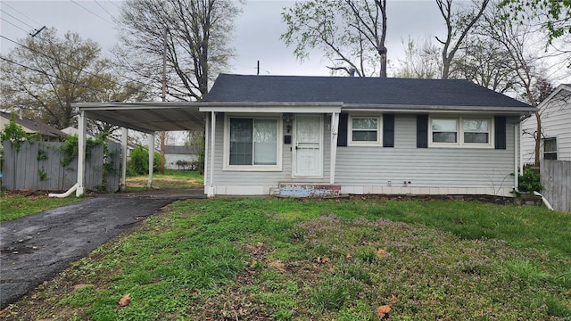 view of front facade featuring a carport, aphalt driveway, fence, and a front lawn