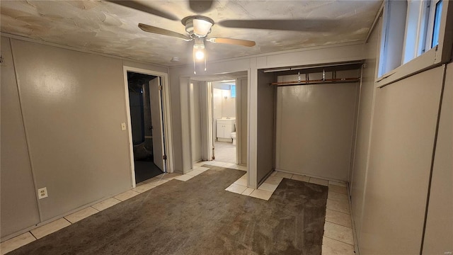 unfurnished bedroom with a closet, light tile patterned flooring, and ceiling fan