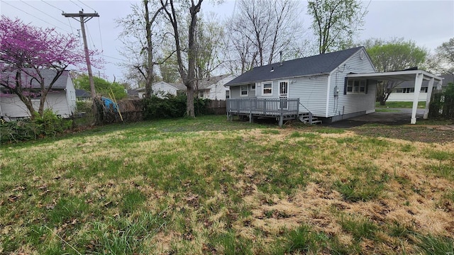 view of yard featuring a carport, a deck, and fence