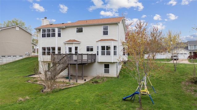 rear view of property featuring a deck, stairs, a lawn, and a chimney