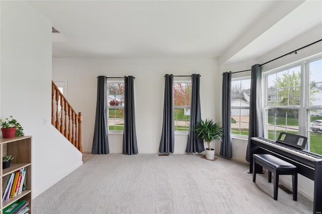 living area with stairs, carpet, and baseboards