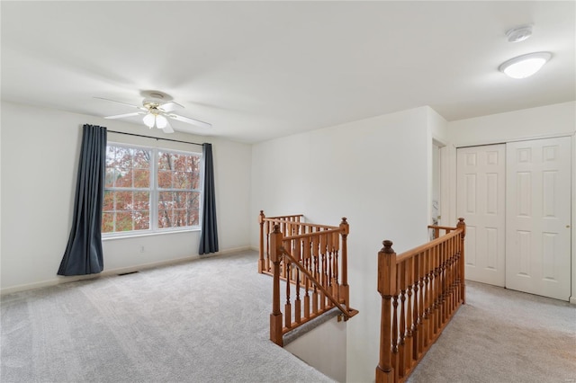 interior space featuring ceiling fan, carpet flooring, baseboards, and visible vents