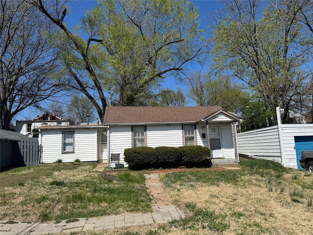 ranch-style house featuring fence and a front lawn