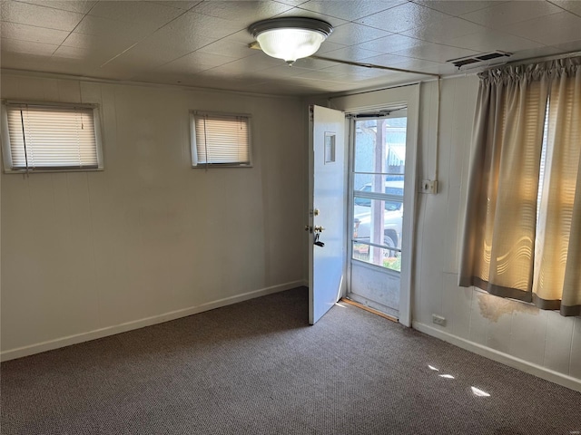 spare room with visible vents, baseboards, and carpet floors