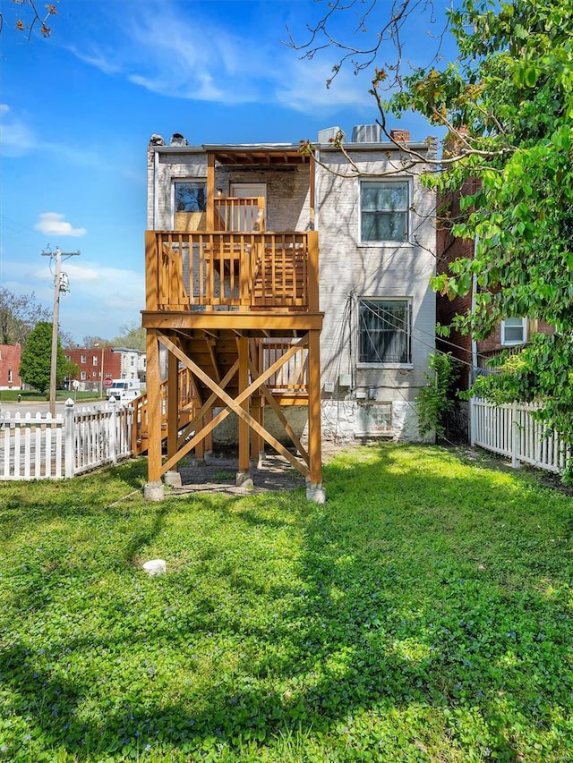 back of property featuring a deck, a yard, and a fenced backyard