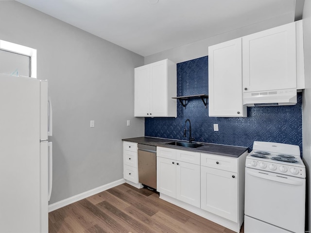 kitchen featuring a sink, under cabinet range hood, dark wood-type flooring, white appliances, and dark countertops
