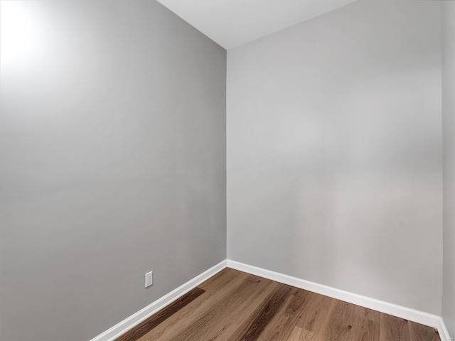 spare room with dark wood-style floors and baseboards