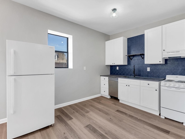 kitchen featuring a sink, dark countertops, under cabinet range hood, light wood-type flooring, and white appliances