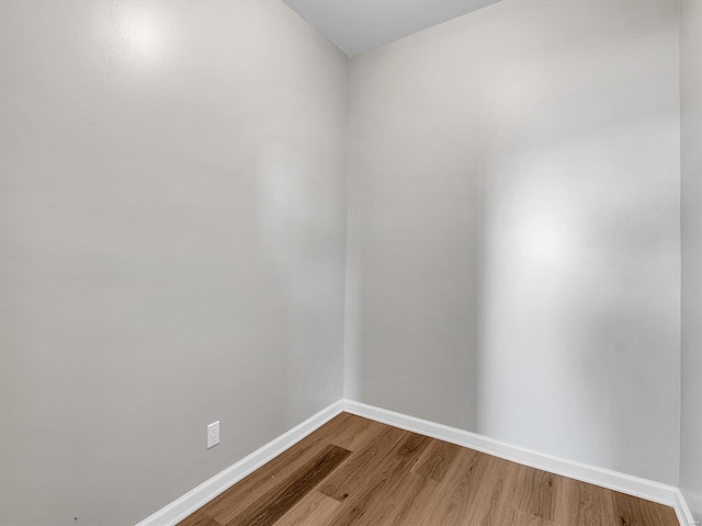 empty room with baseboards and wood finished floors