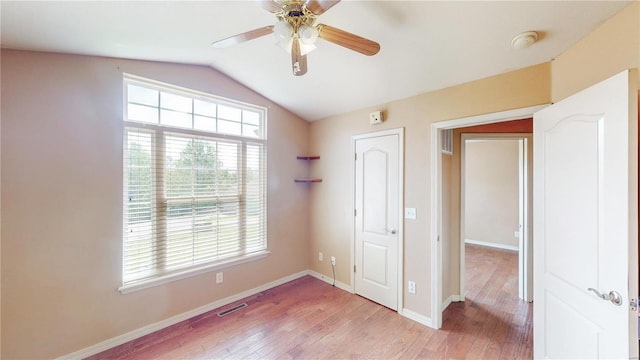 unfurnished bedroom featuring visible vents, light wood finished floors, vaulted ceiling, and baseboards