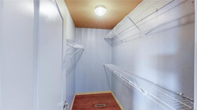 walk in closet with visible vents and wood finished floors