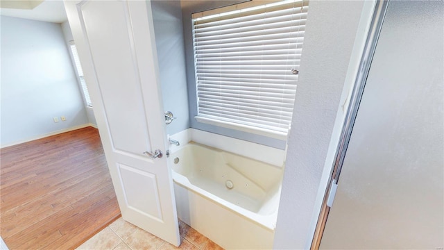 full bath with wood finished floors and a jetted tub
