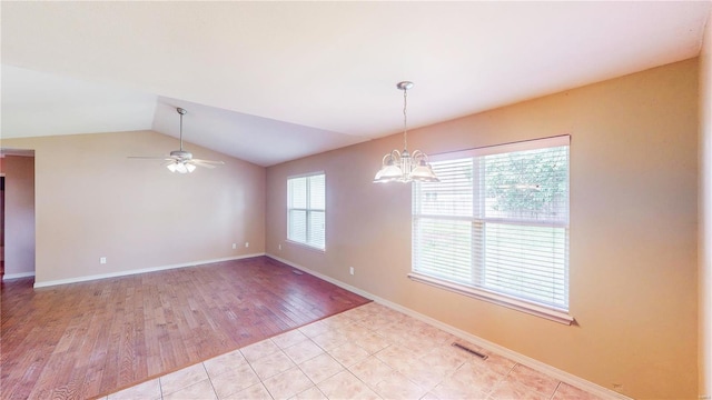 unfurnished room with lofted ceiling, visible vents, light wood-style floors, baseboards, and ceiling fan with notable chandelier