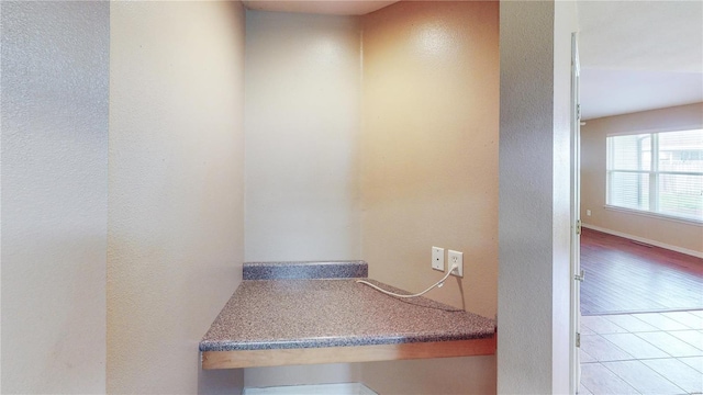 interior space with tile patterned flooring and a textured wall