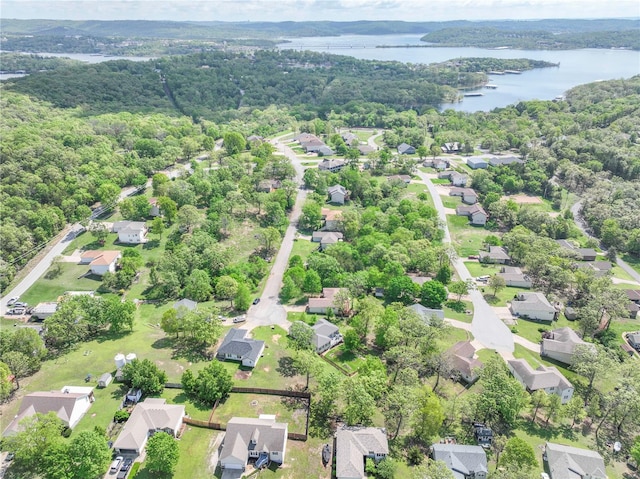 drone / aerial view with a residential view, a water view, and a wooded view