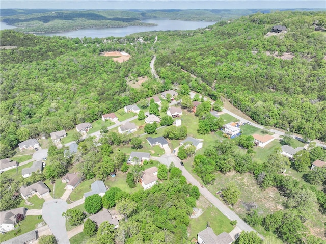 drone / aerial view featuring a wooded view, a residential view, and a water view