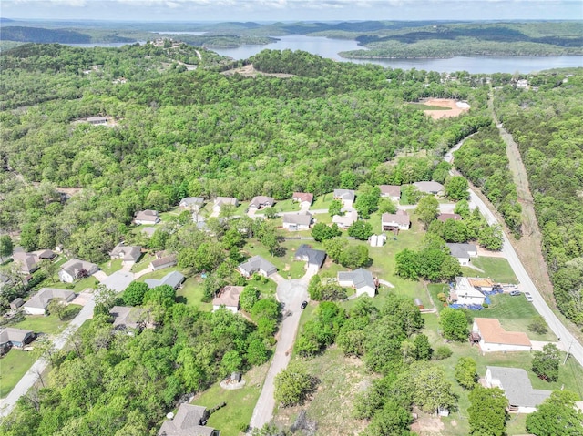 drone / aerial view featuring a water view, a residential view, and a forest view