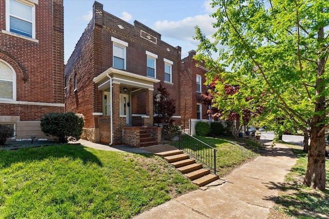 view of front of home with brick siding and a front yard