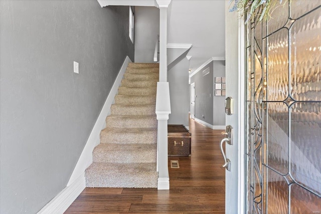 entrance foyer featuring stairway, ornamental molding, wood finished floors, and visible vents
