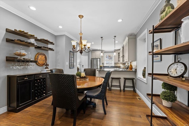 dining area with recessed lighting, a chandelier, crown molding, and dark wood finished floors