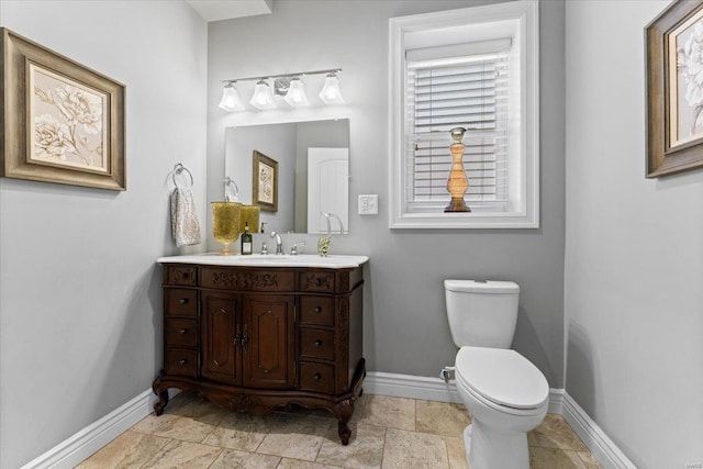 bathroom featuring baseboards, toilet, and vanity