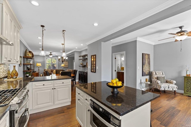 kitchen featuring gas range, white cabinets, open floor plan, and dark wood-style floors