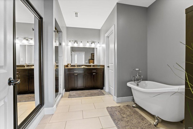 bathroom featuring a soaking tub, baseboards, visible vents, tile patterned flooring, and vanity