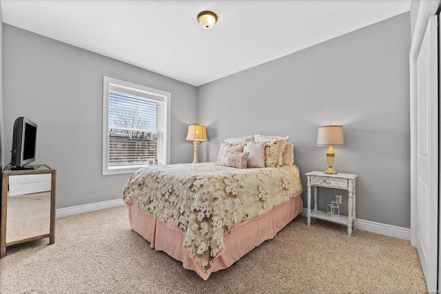 bedroom with baseboards and light colored carpet