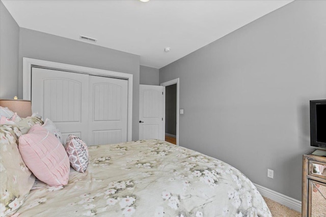 bedroom featuring baseboards, visible vents, and a closet