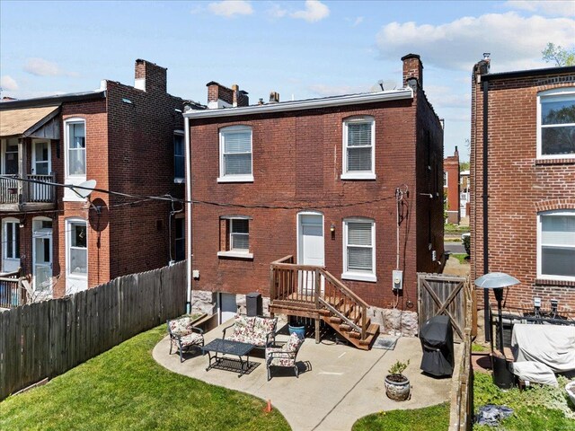 back of house with a fenced backyard, outdoor lounge area, brick siding, and a patio