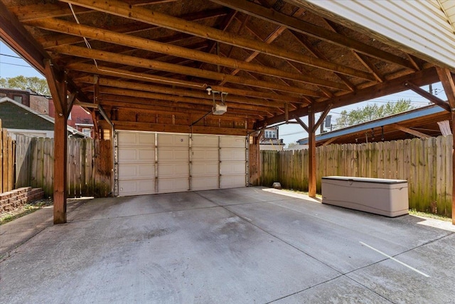 garage with fence and a garage door opener