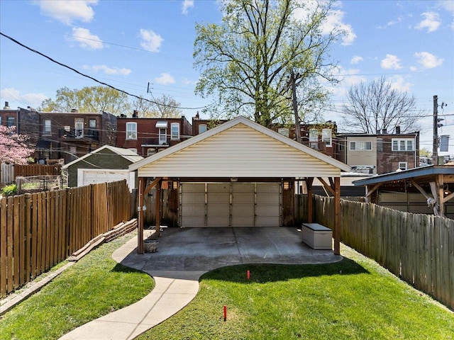 exterior space with a detached garage, a fenced backyard, and a front yard