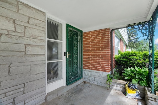 view of exterior entry featuring brick siding