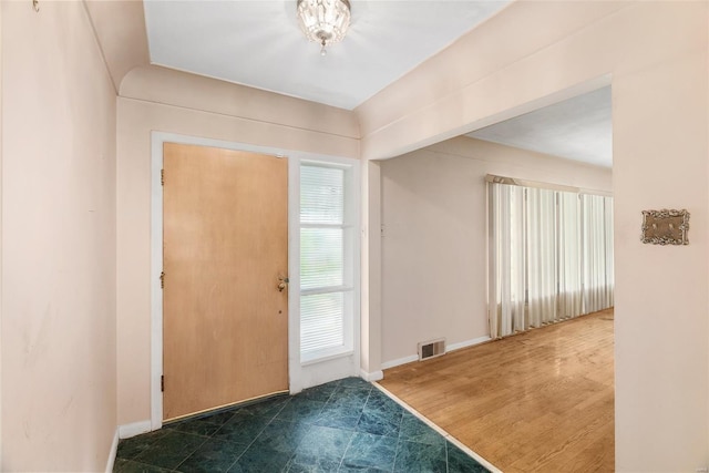 foyer entrance with baseboards and visible vents