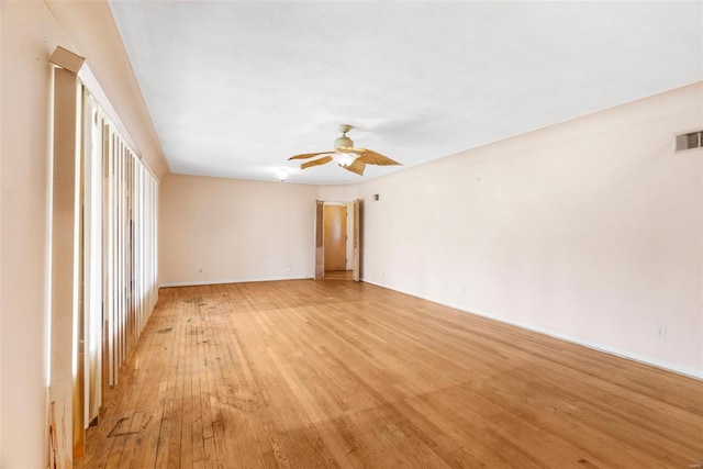 spare room with visible vents, a ceiling fan, light wood-style flooring, and baseboards