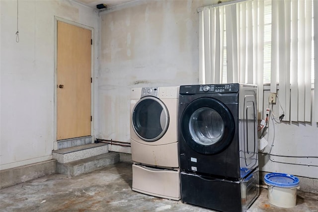 clothes washing area featuring separate washer and dryer and laundry area