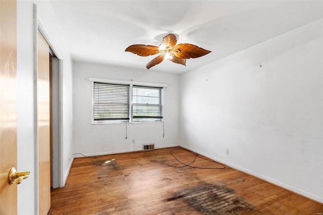 empty room featuring baseboards, visible vents, wood finished floors, and ceiling fan