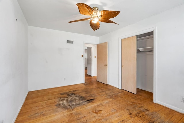 unfurnished bedroom with visible vents, ceiling fan, baseboards, a closet, and wood finished floors