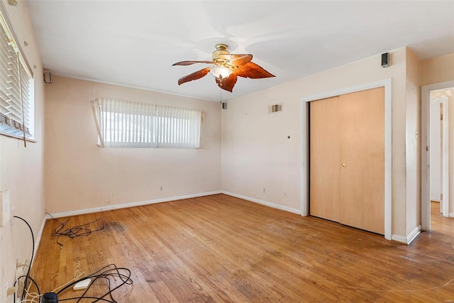 unfurnished bedroom with visible vents, multiple windows, wood finished floors, and baseboards