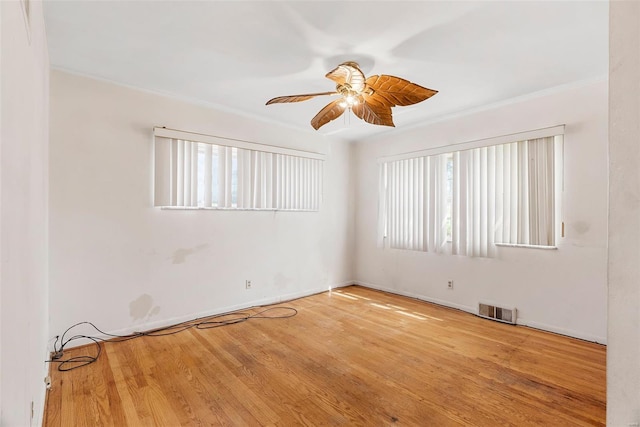 unfurnished room with visible vents, ornamental molding, a ceiling fan, and plenty of natural light