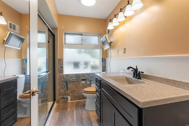 bathroom featuring a stall shower, wood finished floors, toilet, and vanity