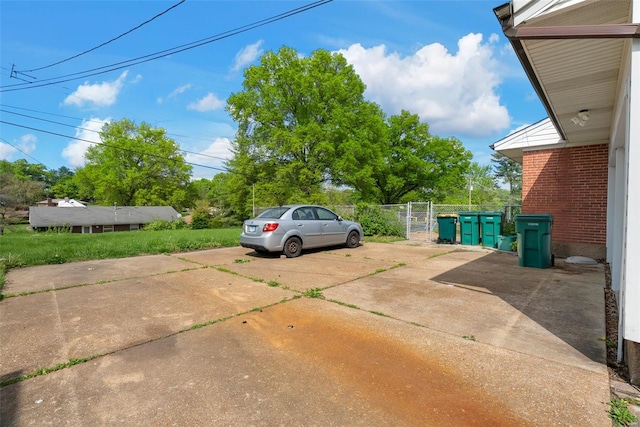 view of vehicle parking with driveway and fence