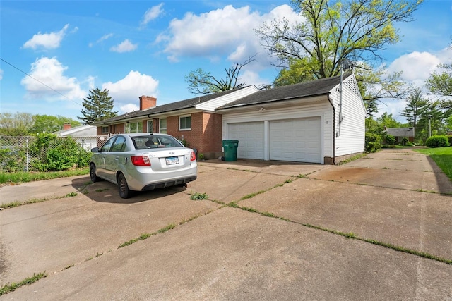 view of home's exterior featuring driveway, an attached garage, and fence