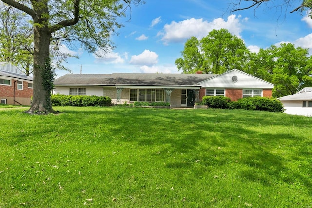 ranch-style house with a front lawn, a chimney, and brick siding