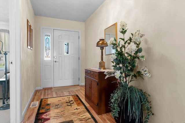 entryway with light wood-style floors, a wealth of natural light, baseboards, and visible vents