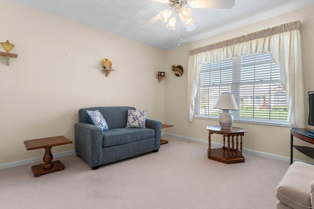 living area with carpet flooring, baseboards, and ceiling fan