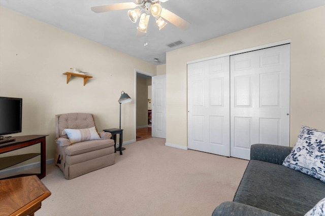 sitting room with carpet floors, visible vents, baseboards, and ceiling fan
