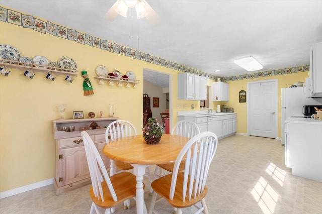 dining area with a ceiling fan and baseboards