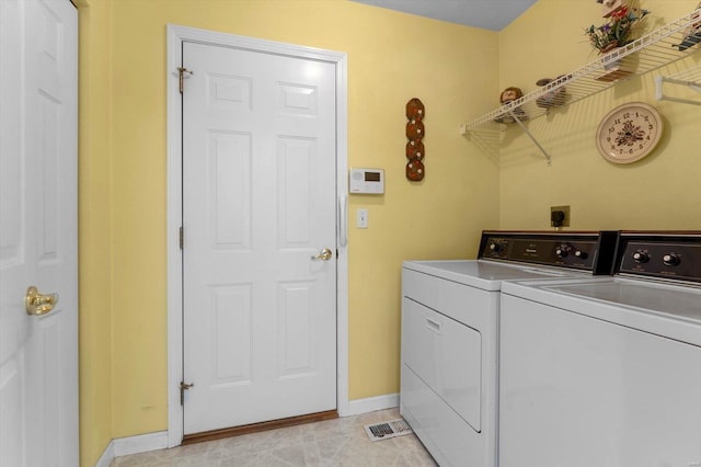 clothes washing area with washer and dryer, baseboards, and laundry area